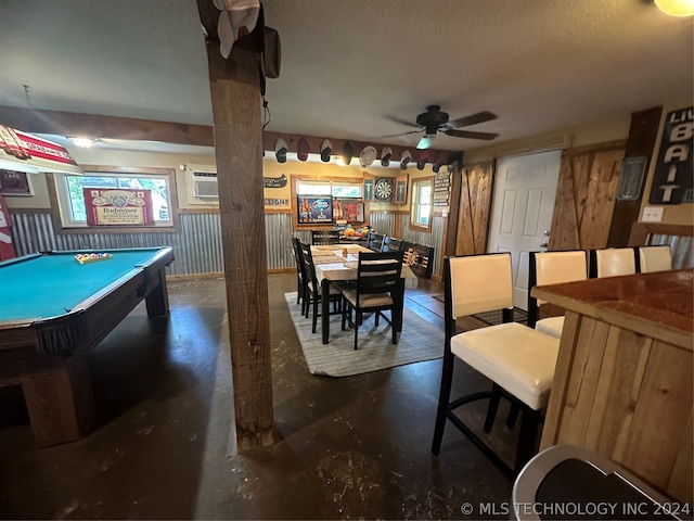 game room featuring pool table, a textured ceiling, wood walls, a wall mounted air conditioner, and ceiling fan