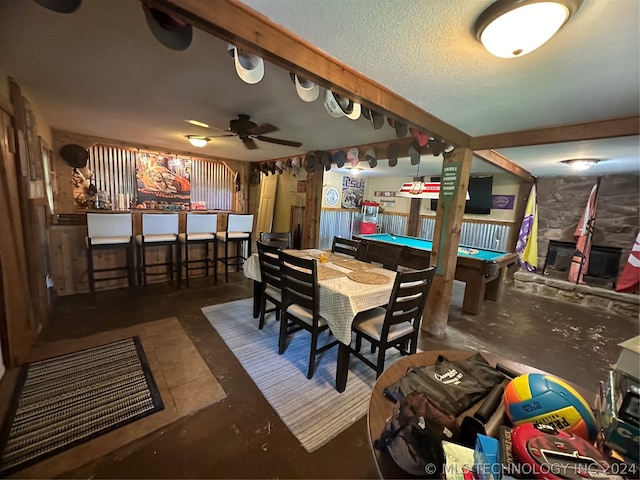 dining area with ceiling fan, a textured ceiling, bar, and pool table