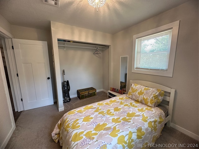 carpeted bedroom with a closet and a textured ceiling