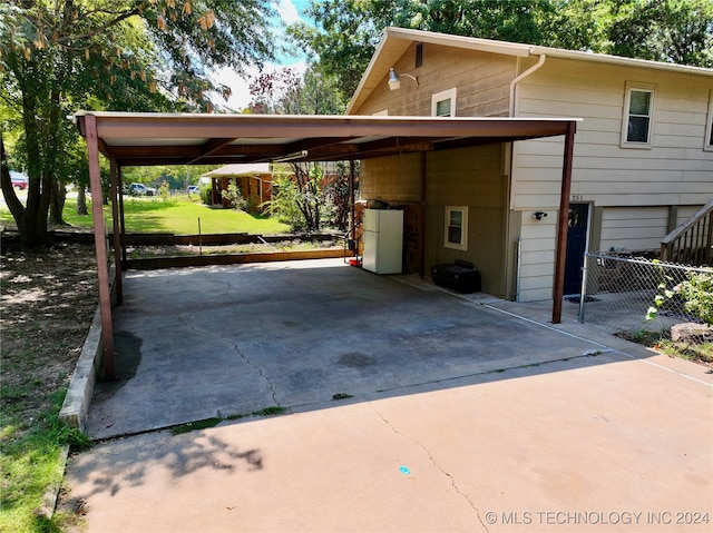 view of car parking featuring a lawn and a carport