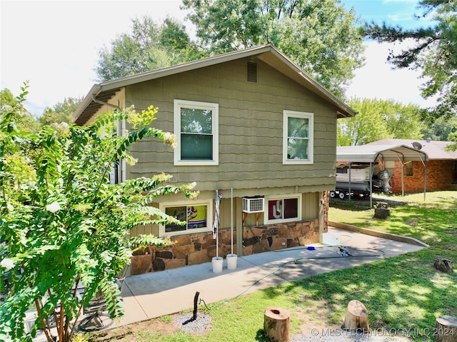 back of property with a lawn, a carport, and a patio area