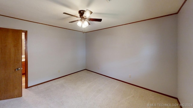 unfurnished room featuring light colored carpet, crown molding, baseboards, and ceiling fan