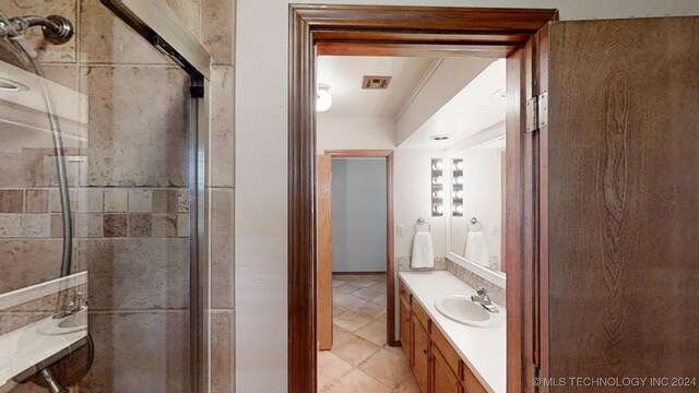 bathroom featuring walk in shower, ornamental molding, vanity, and tile patterned flooring