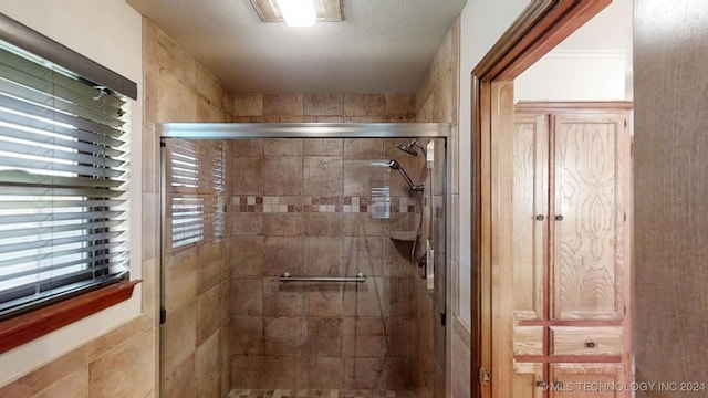 bathroom with a textured ceiling and a shower with shower door