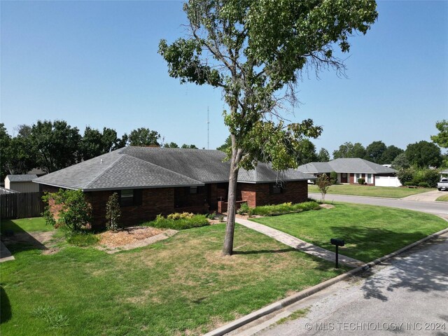 single story home with fence, a front lawn, and brick siding