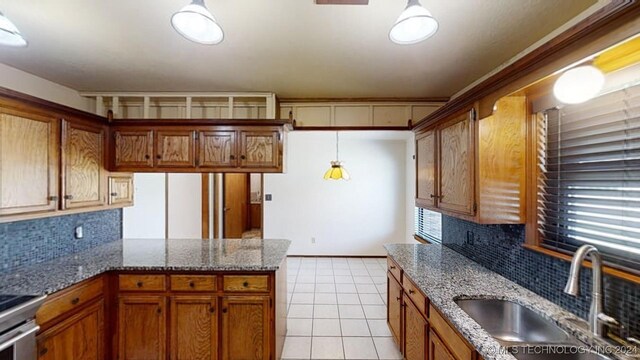 kitchen with light tile patterned floors, pendant lighting, sink, and decorative backsplash