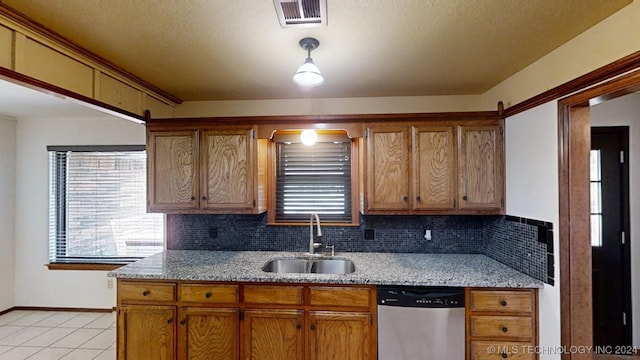 kitchen featuring dishwasher, light stone countertops, backsplash, and sink