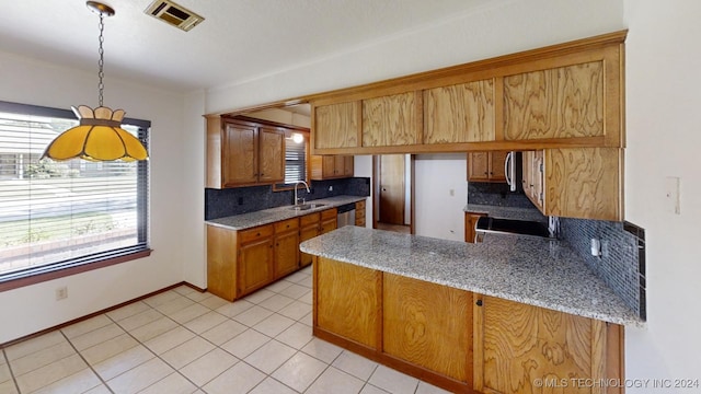 kitchen with visible vents, decorative backsplash, a peninsula, stainless steel appliances, and a sink