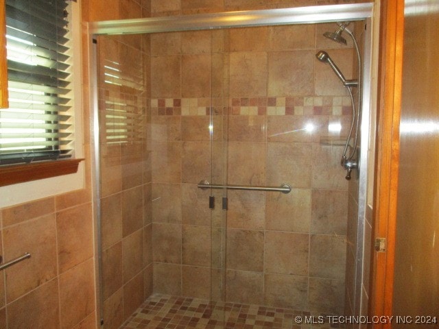 bathroom with a shower with door