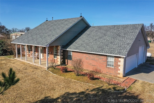 back of house featuring a porch, a garage, and a lawn