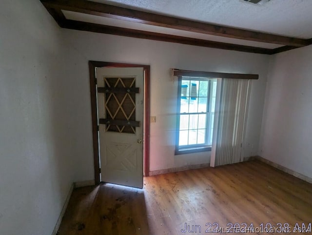 interior space with beamed ceiling and hardwood / wood-style floors