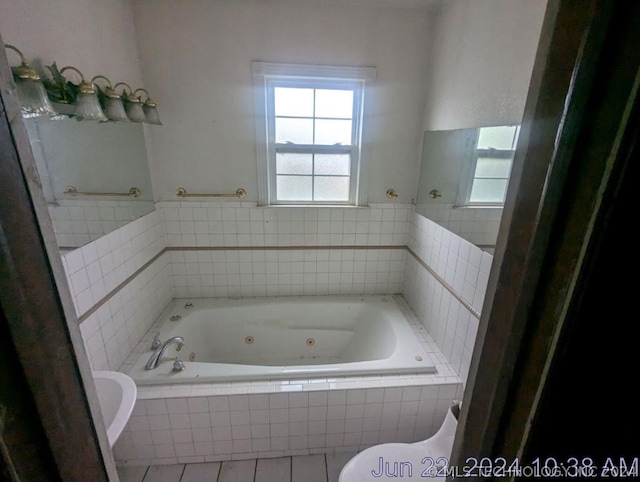 bathroom featuring tile patterned floors, toilet, and tiled bath