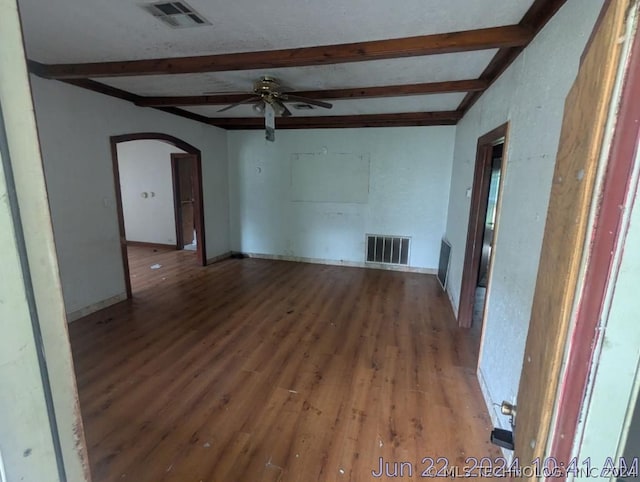 unfurnished living room with beam ceiling, hardwood / wood-style flooring, and ceiling fan