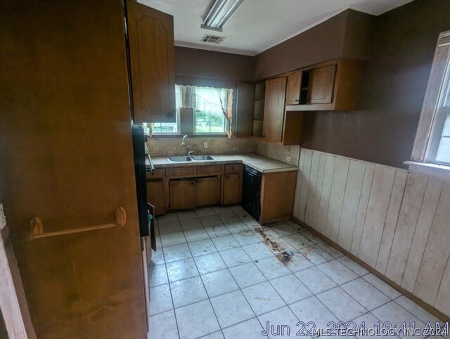 kitchen featuring decorative backsplash, sink, dishwasher, and light tile patterned floors