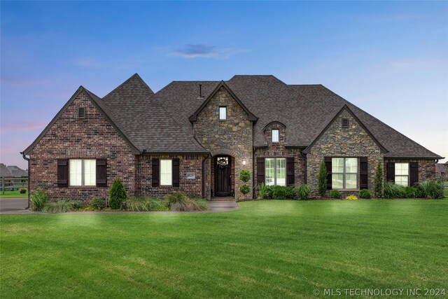 french country style house with a lawn