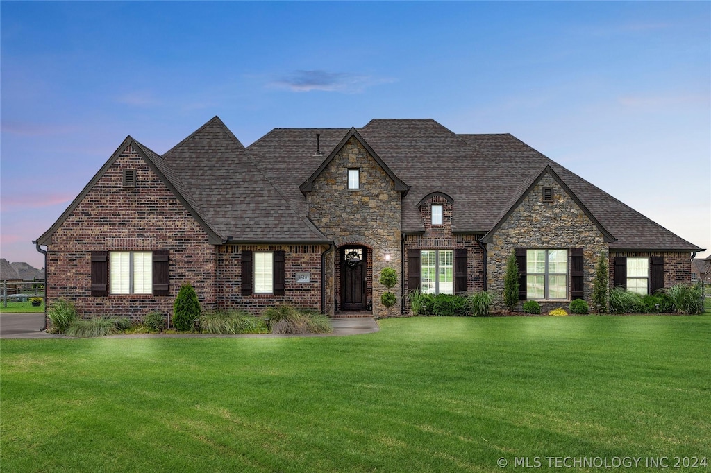 french country home featuring a lawn