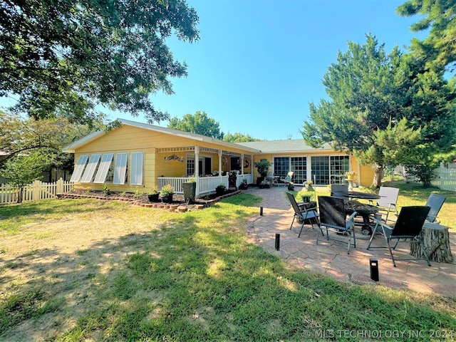 rear view of house with a patio and a lawn