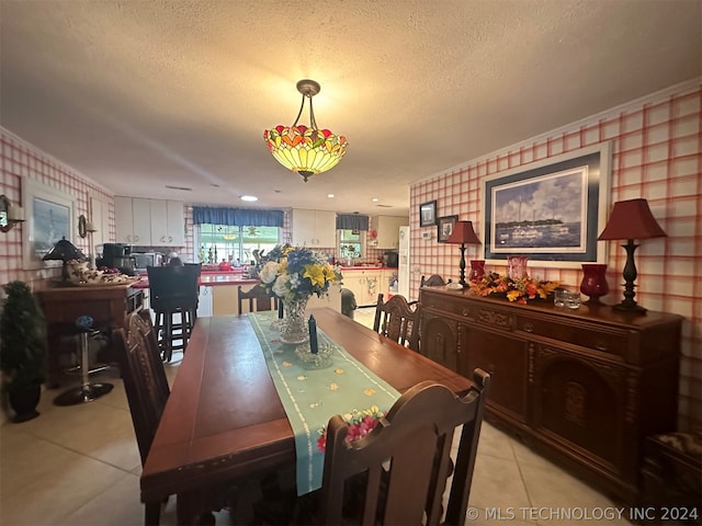 dining area with light tile patterned floors and a textured ceiling