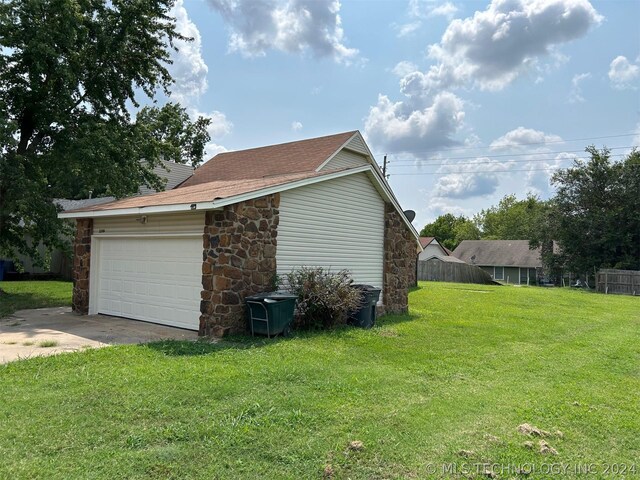 view of side of home featuring a garage and a lawn