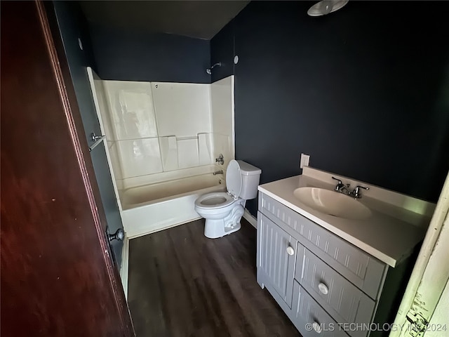 full bathroom featuring hardwood / wood-style flooring, vanity, bathing tub / shower combination, and toilet