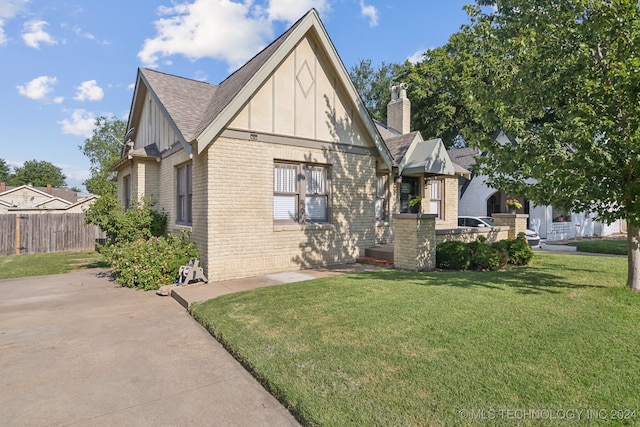 tudor home featuring a front yard