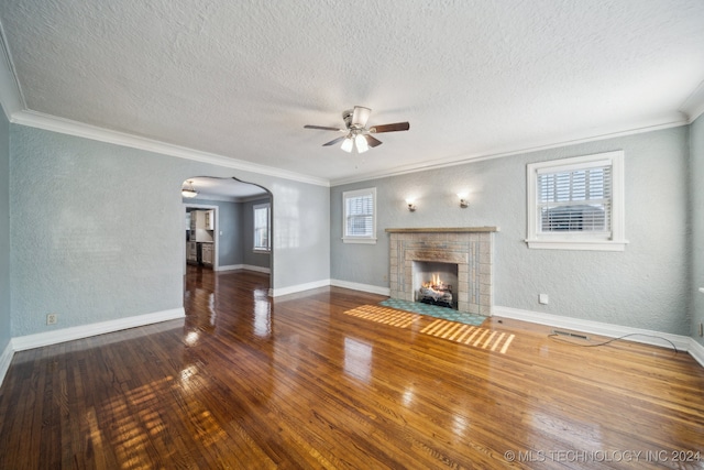 unfurnished living room featuring crown molding, a wealth of natural light, dark wood-type flooring, and a textured ceiling