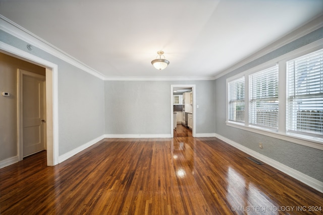 spare room with dark hardwood / wood-style floors and crown molding