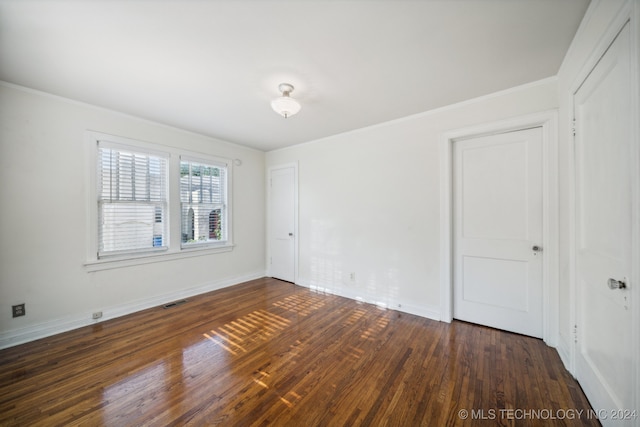 unfurnished room featuring crown molding and dark hardwood / wood-style flooring