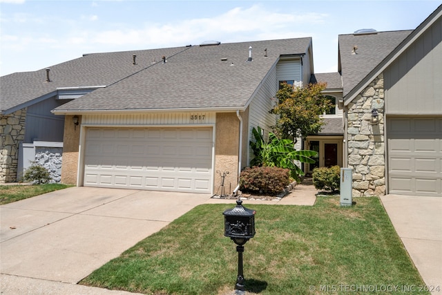 view of front of property featuring a garage and a front lawn