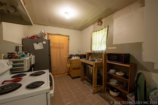 kitchen with sink, electric range, and stainless steel fridge