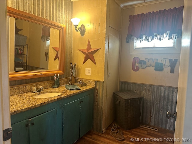 bathroom with wood-type flooring, crown molding, and vanity