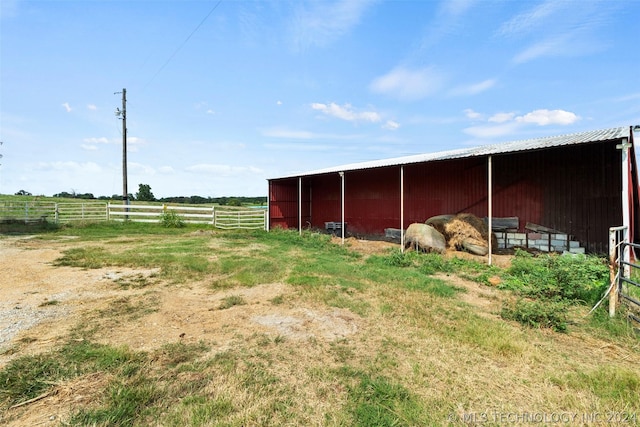 view of horse barn with a rural view