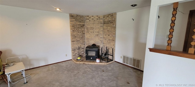 unfurnished living room featuring carpet floors and a wood stove