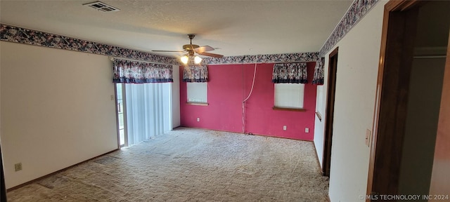 spare room featuring ceiling fan, a textured ceiling, and carpet