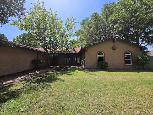 rear view of house featuring a yard