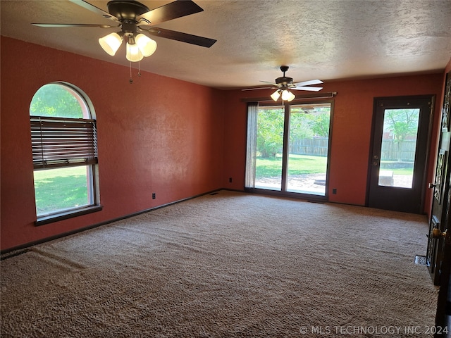 carpeted spare room featuring a textured ceiling and ceiling fan