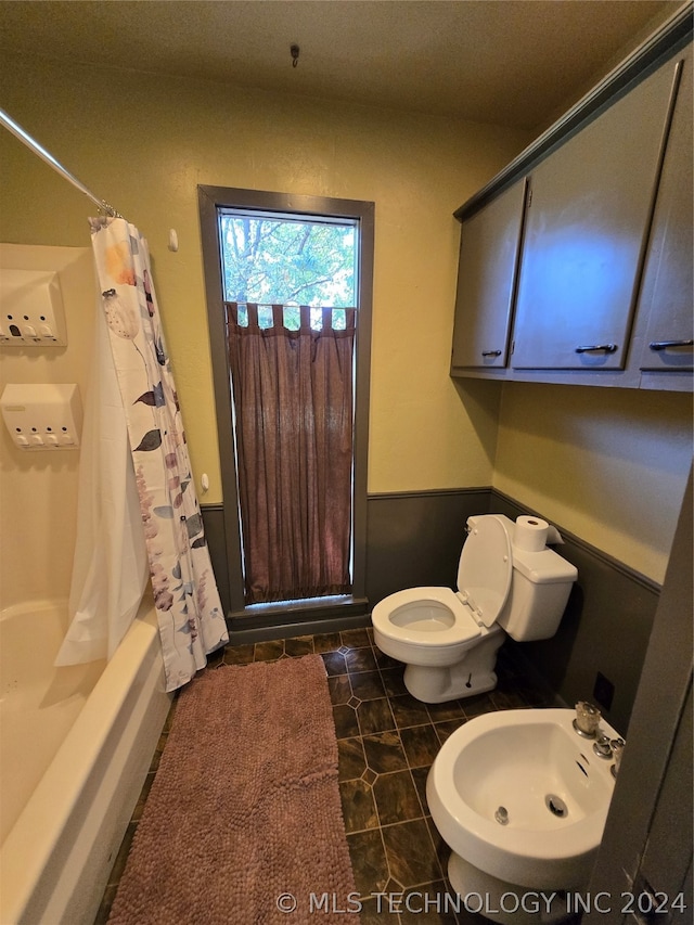 bathroom featuring tile patterned floors, shower / bath combination with curtain, toilet, and a bidet