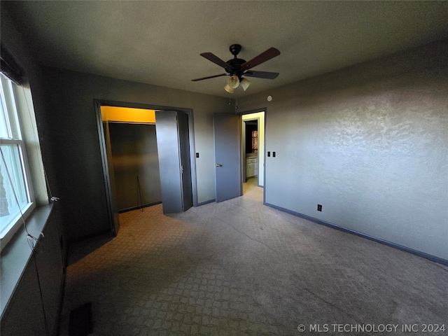 unfurnished bedroom with a textured ceiling, light colored carpet, and ceiling fan