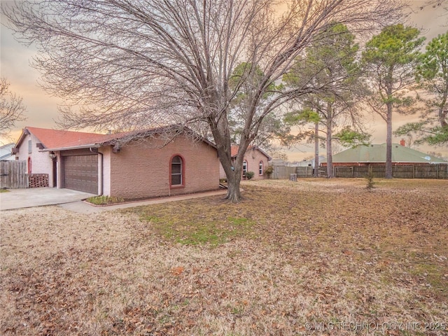 exterior space with a garage, concrete driveway, and fence