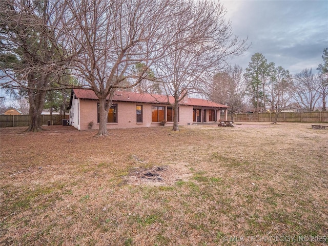 back of house featuring a yard and fence