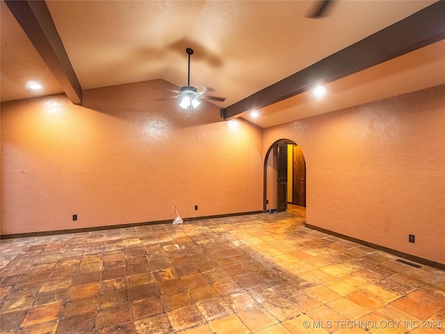 basement with arched walkways, ceiling fan, visible vents, and baseboards