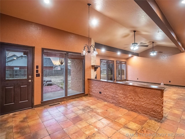 interior space featuring ceiling fan, a textured wall, visible vents, vaulted ceiling, and decorative light fixtures