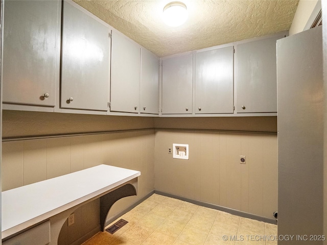 laundry area with cabinet space, visible vents, hookup for a washing machine, hookup for an electric dryer, and a textured ceiling