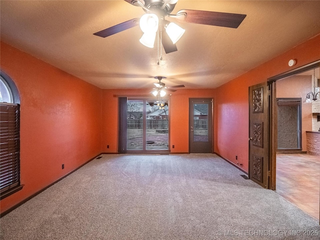 carpeted empty room with a ceiling fan and a textured ceiling