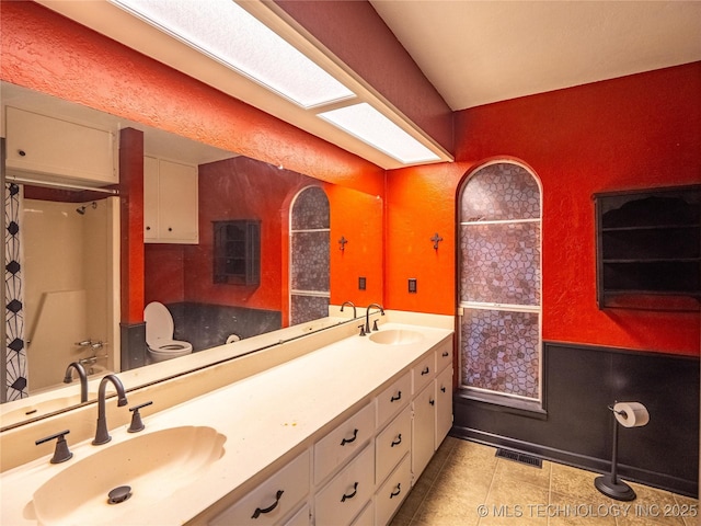 bathroom featuring double vanity, tile patterned floors, a sink, and a shower with curtain