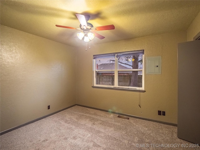 spare room with a textured ceiling, a textured wall, visible vents, electric panel, and carpet