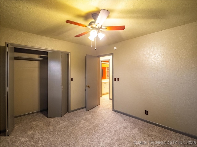 unfurnished bedroom featuring light carpet, a textured ceiling, and a textured wall