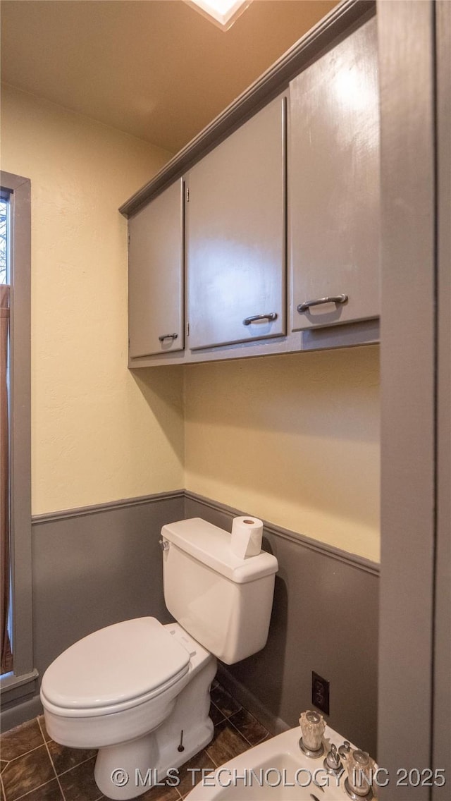 half bath featuring toilet and tile patterned flooring