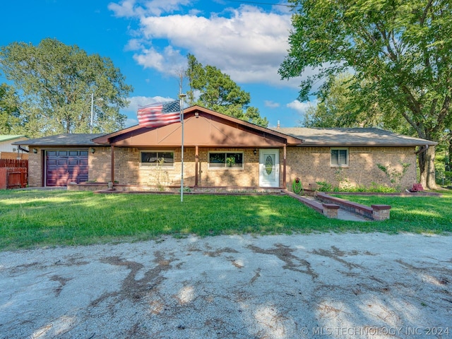 ranch-style house featuring a garage and a front lawn