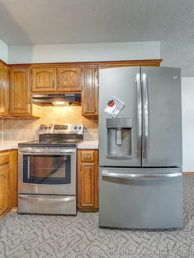 kitchen featuring tasteful backsplash, appliances with stainless steel finishes, and a textured ceiling